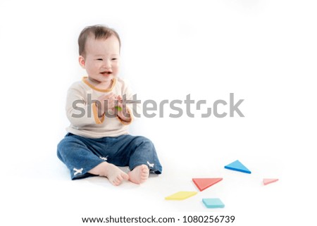 Cute baby sitting playing with color models in white background