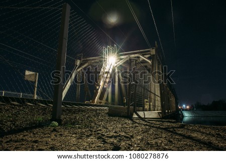 Railroad bridge over river at night, transportation construction, toned