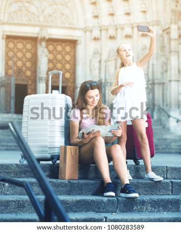 Girl making selfie with phone during traveling with mother in Europe city