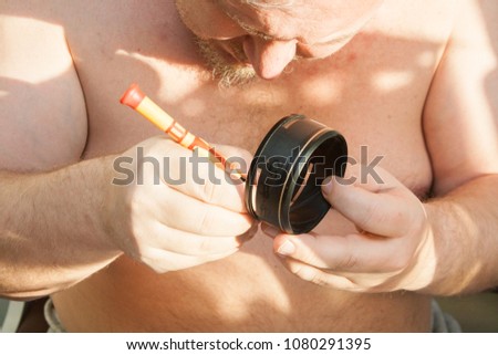 Man trying to repair optical lens for the camera