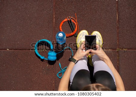 Young girl using phone after workout outdoor