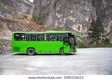 Green travel bus for transport of tourism stop at parking, passenger bus in Shangri-la, China for travel in Balagazon national park. Royalty-Free Stock Photo #1080350612
