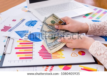 Female hands with dollar on business graphs background