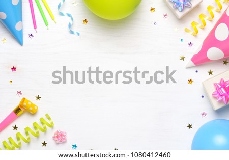 Birthday or party greeting card with copy space. Holiday frame or background with colorful balloon, gift, confetti, star, carnival cap and streamer. Top view. 
