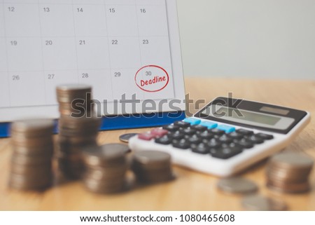 Tax payment season and finance debt collection deadline concept. Money coins stack, calendar and calculator Royalty-Free Stock Photo #1080465608