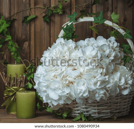 white hydrangeas in basket with green candles
