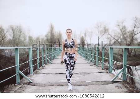Beautiful female athlete walking bridge to morning workout