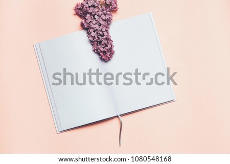 Flat lay and mock up of Notebook and lilac flower. Romantic spring picture. Top view, Place for your text. Copyspace.