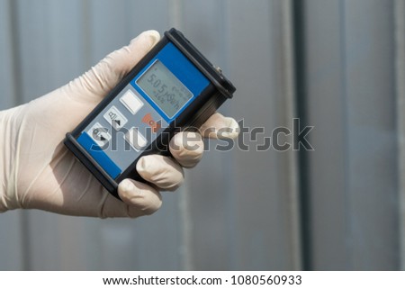 Radiation supervisor in glove with geiger counter checks the level of radiation in the radioactive zone Royalty-Free Stock Photo #1080560933