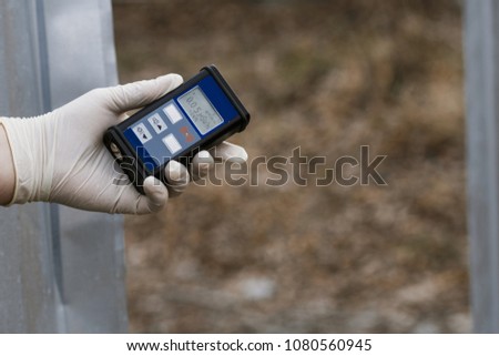 Radiation supervisor in glove with geiger counter checks the level of radiation in the radioactive zone Royalty-Free Stock Photo #1080560945