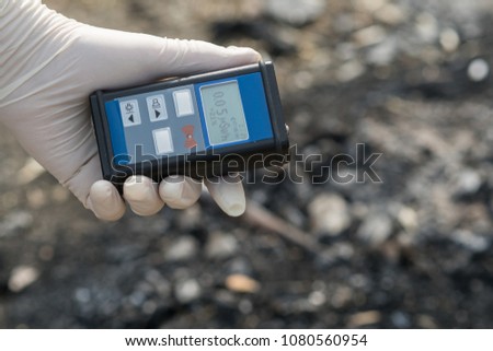 Radiation supervisor in glove with geiger counter checks the level of radiation in the radioactive zone Royalty-Free Stock Photo #1080560954