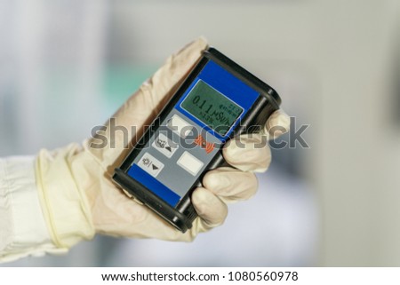 Radiation supervisor in glove with geiger counter checks the level of radiation in the radioactive zone Royalty-Free Stock Photo #1080560978