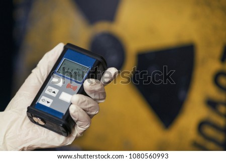 Radiation supervisor in glove with geiger counter checks the level of radiation in the radioactive zone Royalty-Free Stock Photo #1080560993