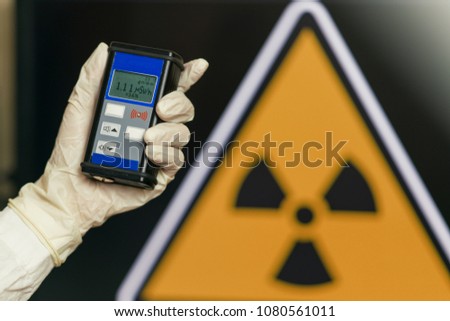 Radiation supervisor in glove with geiger counter checks the level of radiation in the radioactive zone Royalty-Free Stock Photo #1080561011
