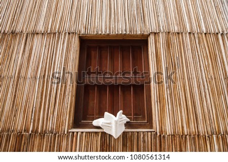 Wall of a thatched house with windows