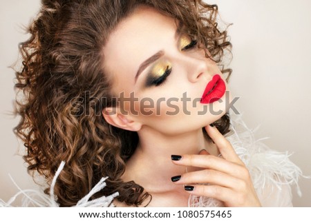 Beautiful woman with fashion make-up. Curly hair. Red lipstick. 