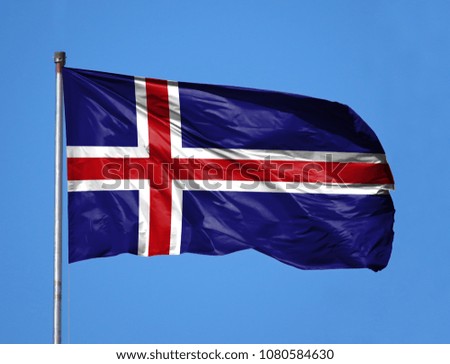 National flag of Iceland on a flagpole in front of blue sky