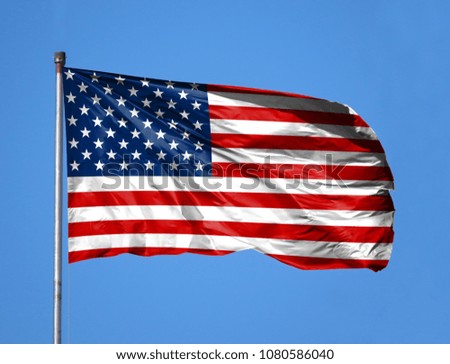 National flag of America on a flagpole in front of blue sky