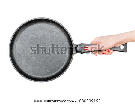 Female's hand holds frying pan. Isolated on white. Top view. Royalty-Free Stock Photo #1080599153