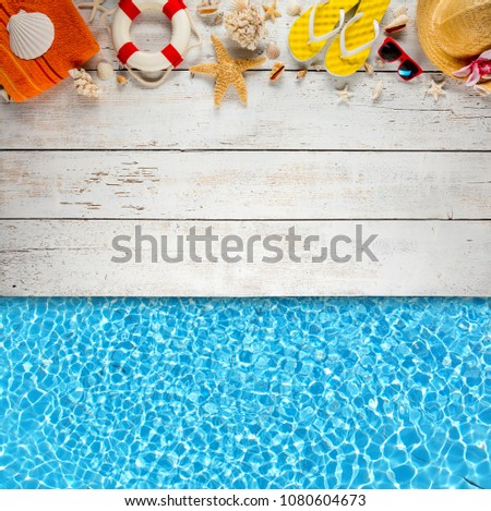 Beach accessories placed on white wooden planks with swimming pool water surface, top view. Summer holidays concept, free space for text. Very high resolution image