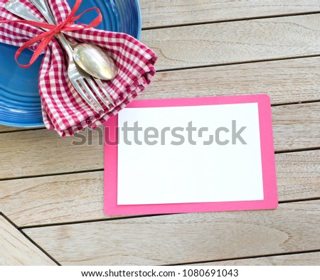 Red White and Blue Picnic Table Place Setting with Blank Card on Rustic Wood Background with room or space for copy, text or your words.  A horizontal with a flat layout that is modern and trendy