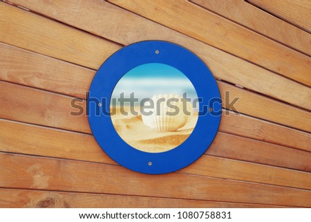 picture of old ship door with a round blue window