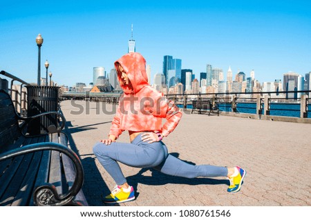Athletic young woman stretching legs before run in New York
