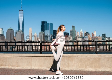 Athletic young woman stretching legs before run in New York