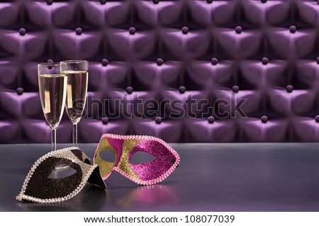 New Years celebration items in front of a button tufted purple silk background