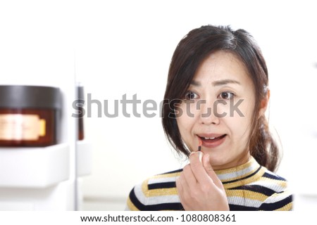 woman making up while watching the mirror