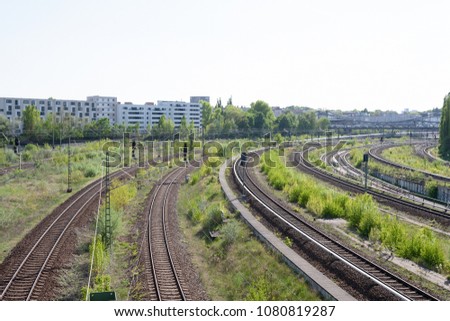 Railway tracks curve, with cityscape in the background