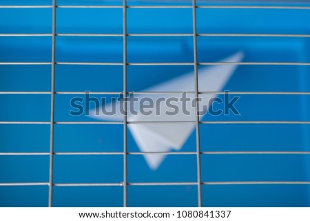 Russia blocks Telegram: paper plane behind bars on a blue background
