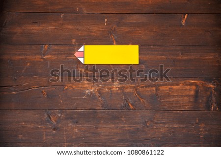 Hiking trail sign on a wooden background. Swiss chalet house in the mountains. 