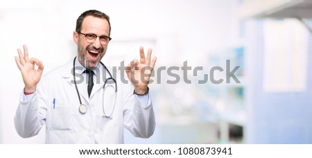 Doctor senior man, medical professional doing ok sign gesture with both hands expressing meditation and relaxation at hospital