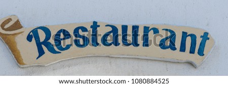 Closeup of restaurant text sign board on the wall outside 