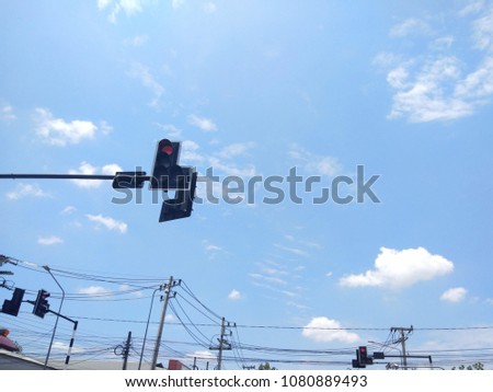 Traffic lights on the high pole with bright sky.