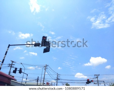 Traffic lights on the high pole with bright sky.