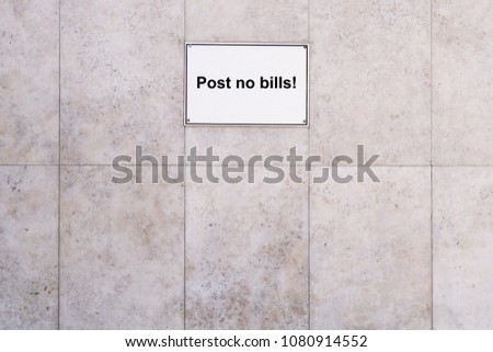 prohibition sign reads post no bills, marble textured stone wall background with copy space