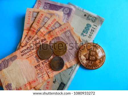 Bitcoin, the virtual money or crypto currency and Indian currency on blue background