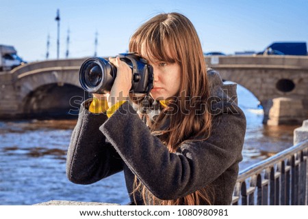 Camera girl next to a river.