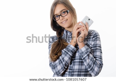 pretty young girl makes selfie portrait on smartphone. teen girl in glasses makes selfie phone. Girl with long hair in hat on a white background. Schoolgirl  in school