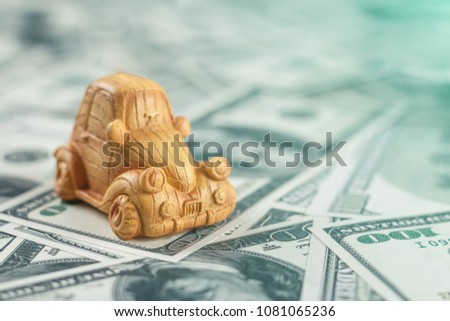 Ceramic toy car on the background of money. Concept of sale and purchase of cars.