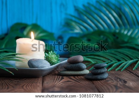 Pyramids of gray zen stones with white candle. Concept of harmony, balance and meditation, spa, massage, relax Royalty-Free Stock Photo #1081077812