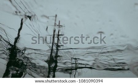 Electric concrete poles with a wires when look from the window of the car,blue aqua sky in the rainy day. 