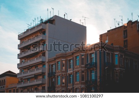 old and new apartments at greece with small lens flare on the top