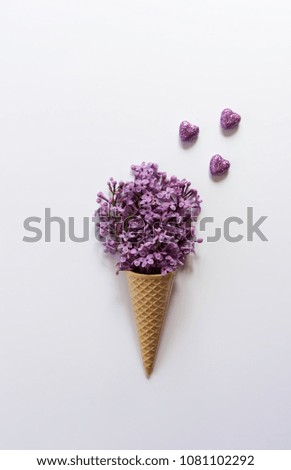 Waffle ice cream bucket with a bouquet of lilac on a white background. Top view