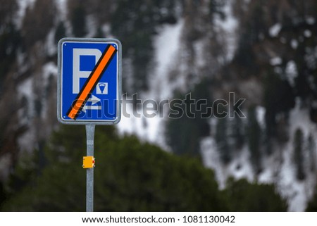 A strikethrough parking sign in the wintertime. Parking is not allowed. The parking space is closed.