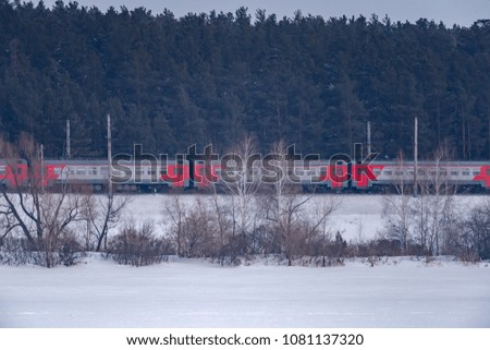City electric train on the background of a snowy landscape