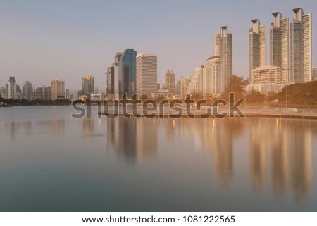 Reflection office building on water lake in public park, cityscape background