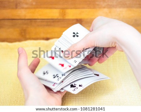 Playing cards in their hands are tossed from one side to the other